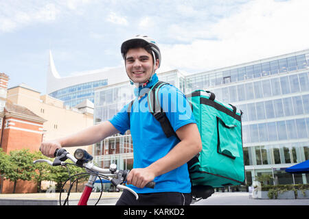 Portrait von Kurier auf dem Fahrrad Lieferung von Nahrung in der Stadt Stockfoto