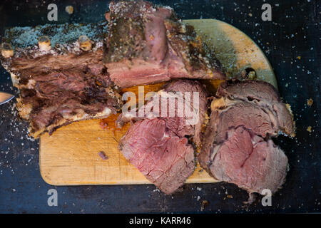 Braten in Scheiben geschnitten auf einer Holzplatte Stockfoto