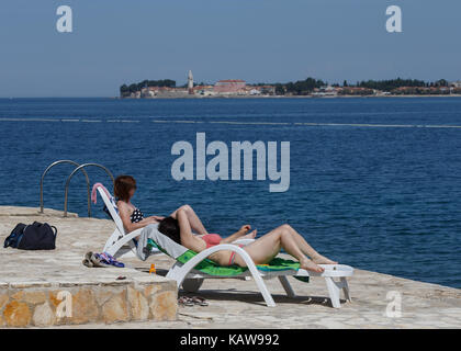 Touristen entspannen im Liegestuhl am Strand, Lanterna, Novigrad, Kroatien. Stockfoto