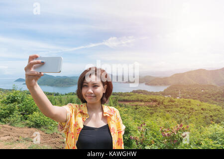 Weibliche Reisende selfie mit Ihrem Smart Phone und schöne Landschaft bei kanchanaburi Thailand Stockfoto