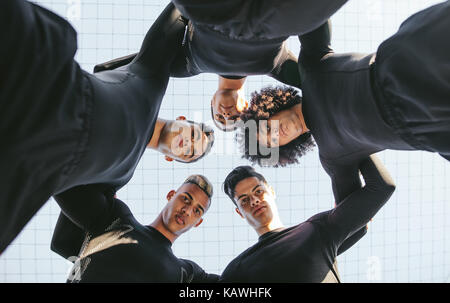 Low Angle View von fünf Fußball Team drängeln. Jungen Fußball-Spieler in einem Kreis stehen. Stockfoto