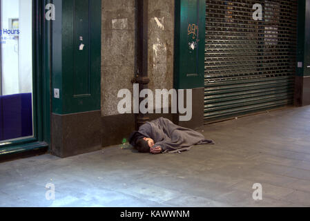 Hielanman's Umbrella highlanders Regenschirm Glasgow junge Obdachlose Junge sieht tot, als er auf dem Boden bewusstlos schläft wie Stockfoto