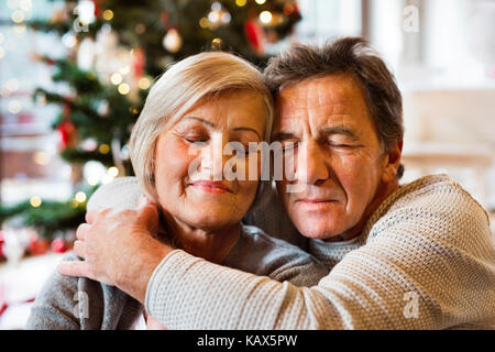 Senior Paar vor Weihnachtsbaum, aus der Nähe. Stockfoto