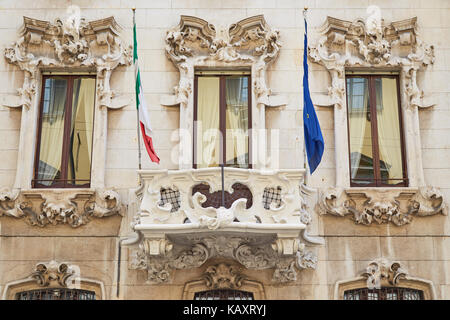 Ein Teil der alten Haus in Mailand mit Reliefs auf dem Windows und Flaggen der Europäischen Union und der Italienischen Stockfoto