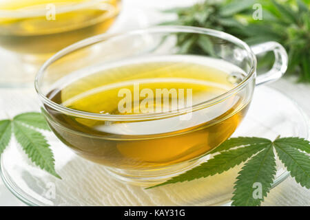 Eine Tasse heißen Tee mit Marihuana Knospen und Blätter. Stockfoto