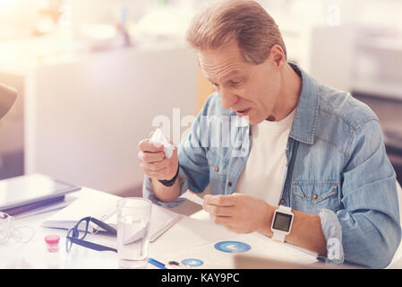 Kranken erwachsenen Mann lesen Sie die Anweisungen auf der Arzneimittel Stockfoto