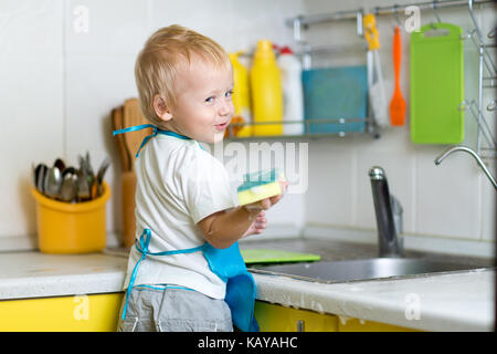 Kleiner Junge Mutter abwaschen in der Küche zu helfen Stockfoto