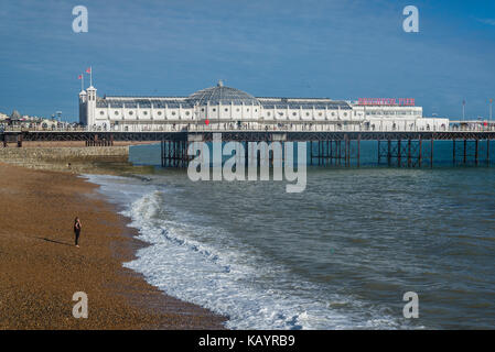 Frau am Strand und Palace Pier von Brighton, Brighton, England, Großbritannien Stockfoto