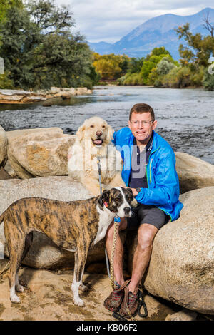 Porträt eines Mannes mit zwei Hunden, Arkansas River, Salida, Colorado, USA Stockfoto