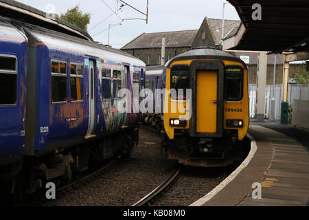 Zwei Personenzüge. Klasse 156 super Sprinter dmu Ankunft in Carnforth Bahnsteig 1 neben Klasse 150 Sprinter dmu Warten in der Plattform 2. Stockfoto