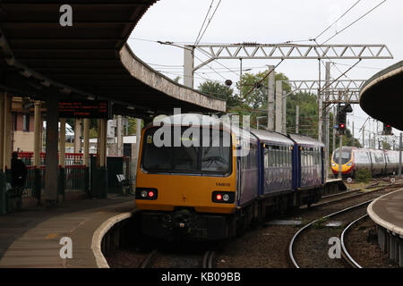 Klasse 144 Pacer dmu in Carnforth Station wartet der West Coast Main Line mit einem nördlichen Service nach einem Jungfrau pendolino nach Norden verläuft. Stockfoto