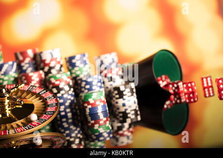 Casino Konzept. Roulette, Chips, Karten und Würfel auf bunten Bokeh. Stockfoto