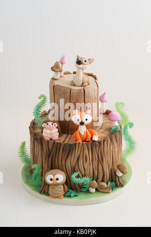 Verzauberten Wald Wald themed Fondant Kuchen mit einem Igel, Rehe, Eule, Fox, Schnecke, Baumstamm, Farne, Pilze und Blätter auf weißem Hintergrund Stockfoto