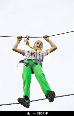 Junges Mädchen zu Fuß auf einem Seil an einem Seil Park Stockfoto