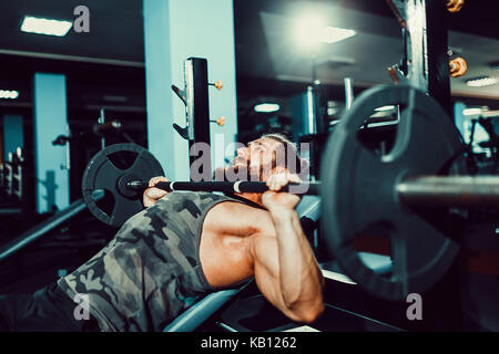 Hübscher junger Mann tun Bankdrücken trainieren Sie im Fitnessraum Stockfoto