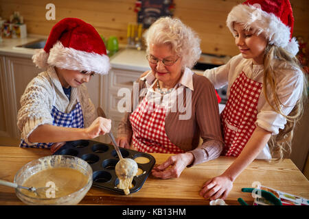 Kinder Plätzchen backen mit Oma auf Weihnachten Stockfoto