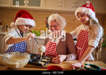 Kinder Plätzchen backen mit Oma auf Weihnachten Stockfoto