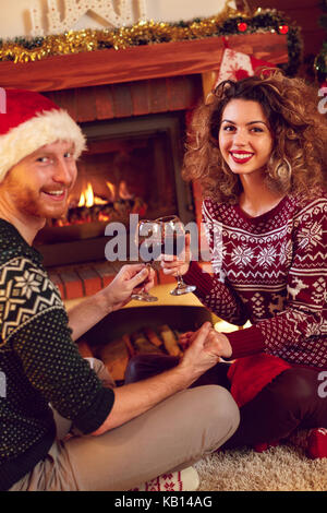 Paar in Liebe für Weihnachten Toasten mit Gläsern Wein Stockfoto