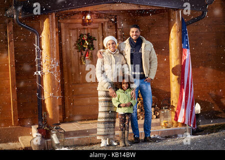 Portrait von afro-amerikanische Familie vorne Holzhaus auf Weihnachten Stockfoto