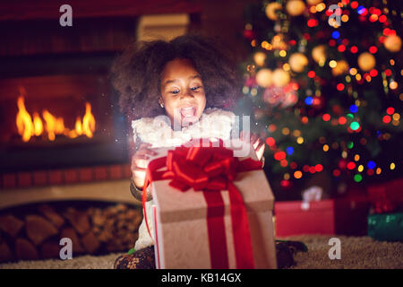 Lassen sie sich überraschen Mädchen öffnen Weihnachtszauber präsentiert Stockfoto