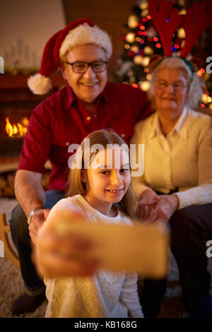 Glückliche Familie auf Weihnachten mit Smartphone unter selfie Stockfoto