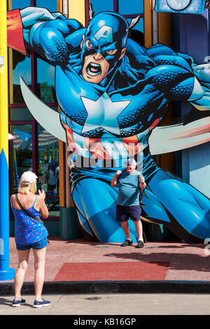 Touristische in seinem Foto aufgenommen, als er wirft auf ein Poster von Captain America, Universal Studios, Orlando, Florida, USA Stockfoto