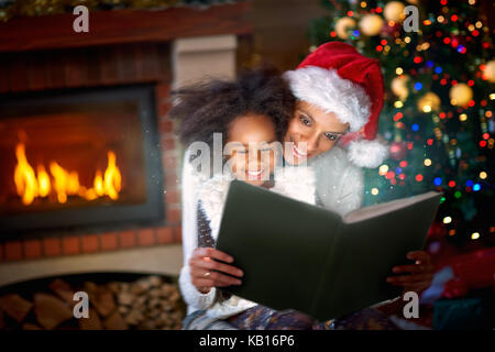 Afro-amerikanische Mutter und Tochter in der Magie weihnachten Märchen genießen Stockfoto