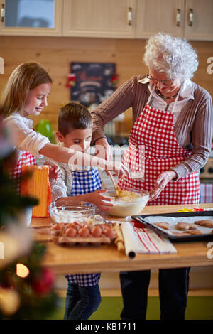 Kinder und Großmutter Vorbereitung xmas Cookies - Familie Zeit Stockfoto