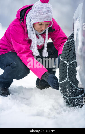 Junge Frau, winter Ketten auf dem Auto Stockfoto