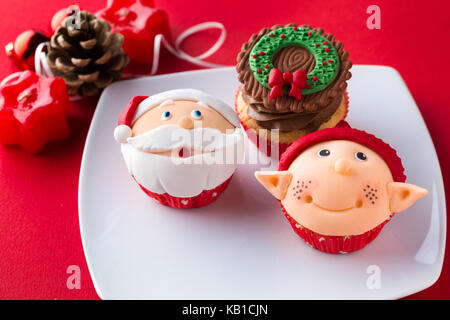 Drei dekorative weihnachtliche Cupcakes auf weiße Platte Stockfoto