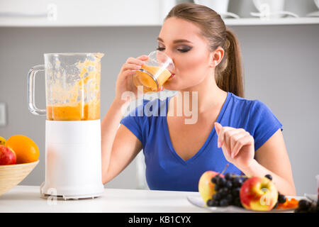 Junge Mädchen trinken lecker Saft, gesunde Früchte Smoothies Stockfoto