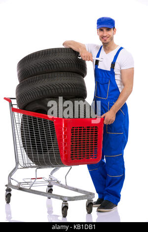 Junge Mechaniker mit Reifen im Warenkorb Stockfoto