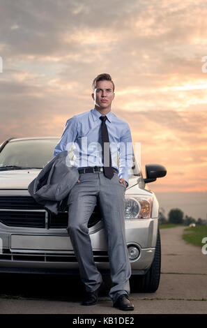 Hübscher junger Mann lehnte sich auf seinem Auto. Attraktive gorgeous guy Standing, draußen - außen Stockfoto
