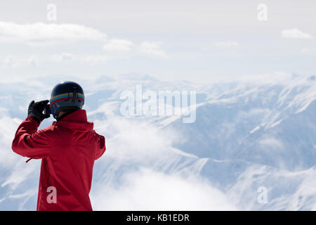 Snowboarder macht Foto auf Kamera und Schnee Berge im Nebel im Hintergrund. Kaukasus Berge im Winter, Georgien, Region Gudauri. Stockfoto