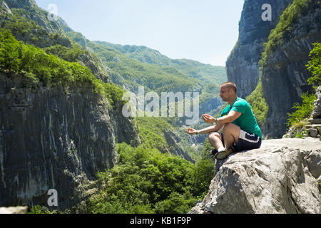Man saß oben auf der Rock und meditieren Stockfoto