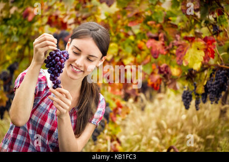 Junge Frau mit Strauß roter Trauben Stockfoto