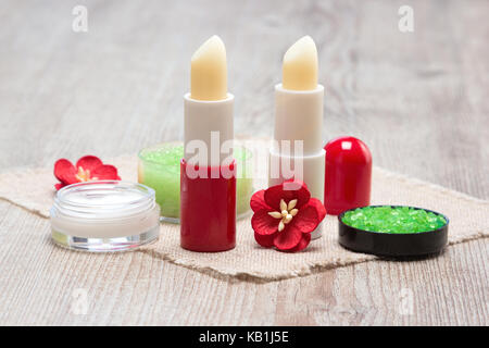 Kosmetik für die Lippe Hautpflege: Meersalz, natürlicher Honig Peeling mit ätherischen Ölen, lip Cream und Balsame mit Blumen auf Sack Serviette Stockfoto