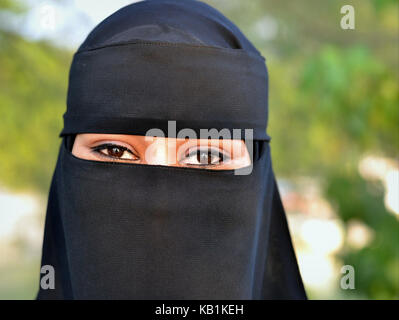 Flitterwochen junge Sudanesische Frau, gekleidet in schwarz schwarze Niqab und Burka mit nur einer kleinen Öffnung für Ihren schönen, mandelförmigen Augen Stockfoto