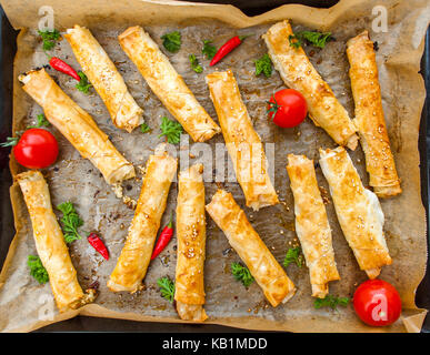 Hausgemachte Zigarette boreks in einem Backblech mit Tomaten und Kräutern Stockfoto