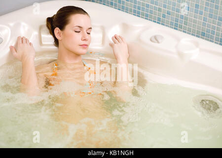 Junge Frau entspannt im Whirlpool, Stockfoto