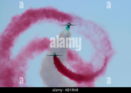 Ein British Aerospace Hawk der Saudi Hawks Kunstflugstaffel Faß - Rollen um andere während eines Air Display Stockfoto