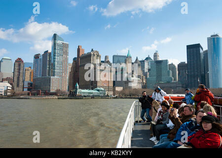 Skyline von New York, Touristen auf der Fähre vom Hafen von New York, Battery Park, Fährfahrt nach Liberty Island, New York, NY, USA. Stockfoto