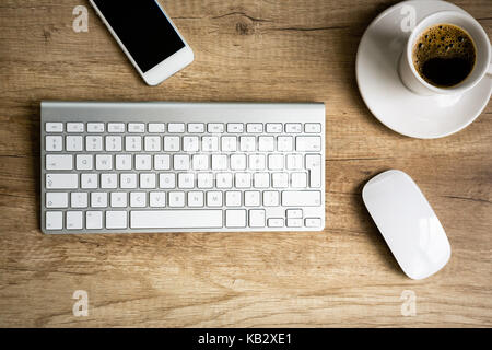 Moderner Arbeitsplatz, Tastatur und Kaffee Tasse über Holz- Tabelle Stockfoto