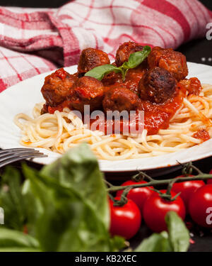 Pasta Spaghetti mit hackbällchen und Tomatensauce auf schwarzem Hintergrund Stockfoto