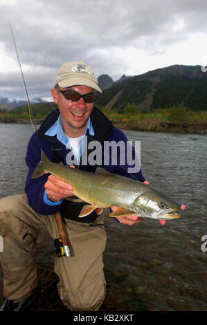 Fischer Holding ein Saibling oder Dolly Varden gefangen beim Fliegenfischen in der Nähe von Alaska Chignik Stockfoto