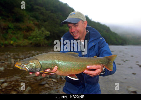 Fischer Holding ein Saibling oder Dolly Varden gefangen beim Fliegenfischen in der Nähe von Alaska Chignik Stockfoto