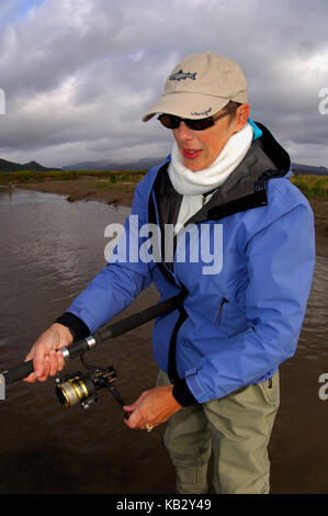 Eine Frau, die Fischerei auf Lachs auf einem entfernten Alaska River Stockfoto