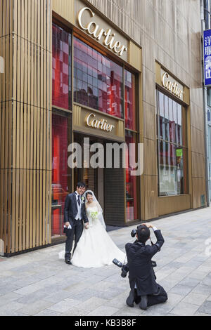 Japan, Honshu, Tokyo, Ginza, Braut und Bräutigam posiert vor der Cartier business, Fotograf, Stockfoto