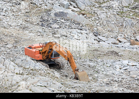 Eine orangefarbene Bagger weg auf den Berg. Stockfoto