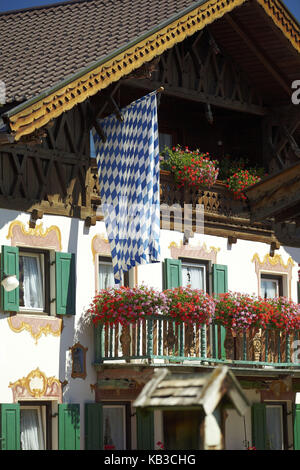 Bayerisches Haus mit bayerischer Flagge und Lüftlmalerei (Art Trompe l'oeil auf Häusern in Bayern), Sommer, Stockfoto